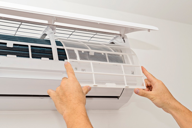 Man performing maintenance on a ductless unit