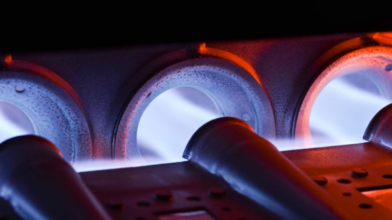 Closeup Shot Of Home Furnace Burner Ignited With Crimson Blue Flame