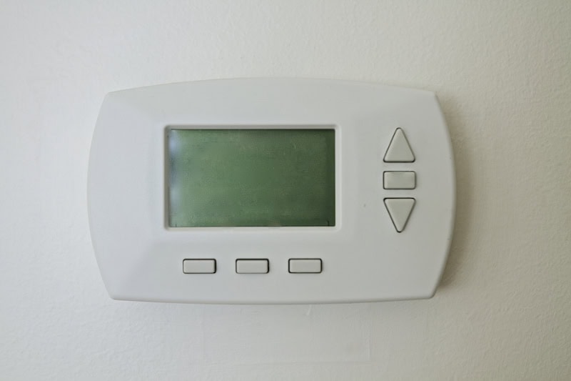 Why Is My Thermostat Blank? Photo of a digital thermostat mounted on a wall with a blank screen.